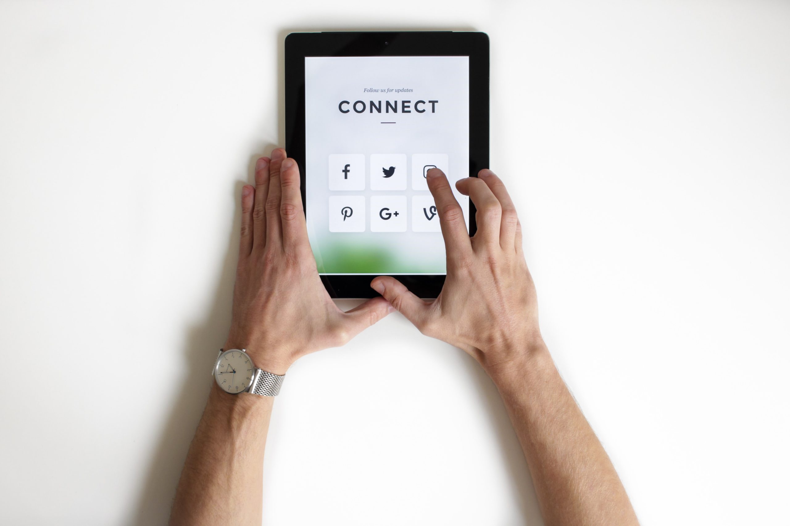 Caucasian hands hold a tablet that reads Connect and has the symbol of the most known social networks. Digital presence is all about brand recognition.